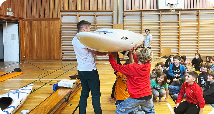 élèves dans un gymnase avec un athlète et un aviron
